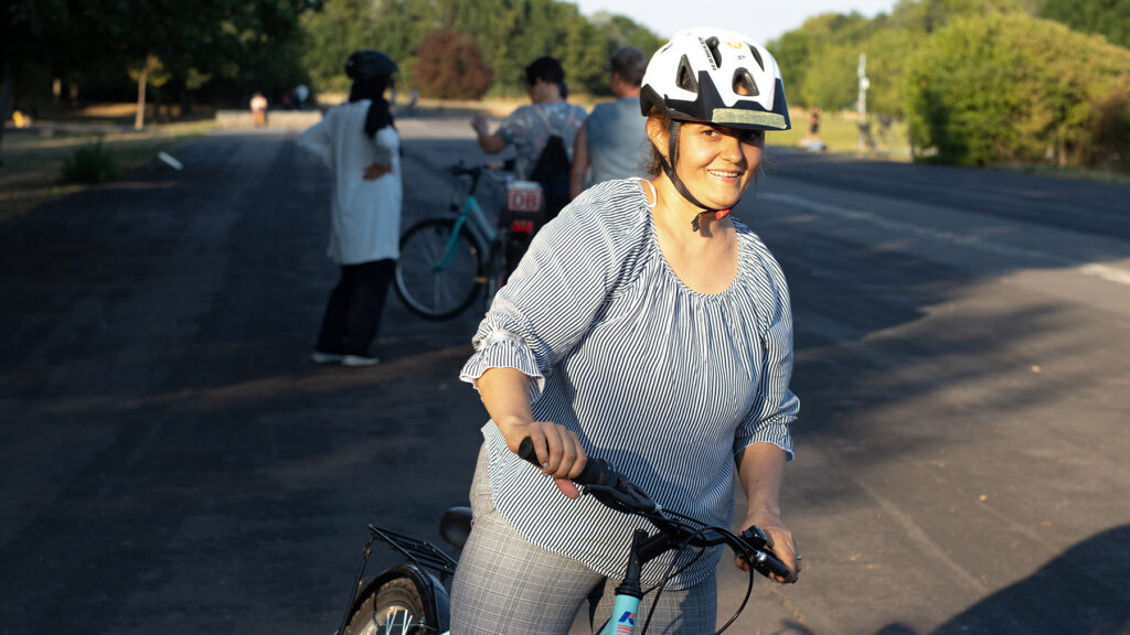 Eine junge Frau mit ihrem Fahrrad, sie lernt Fahhradfahren bei Bike Bridge Frankfurt